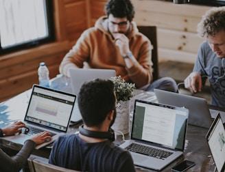 Men discussing marketing strategy with laptops and coffee in office