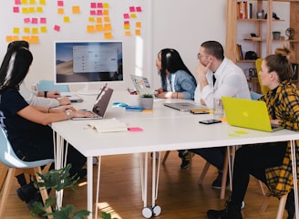 Team collaborating during a marketing meeting with laptops and presentation screen, illustrating cli