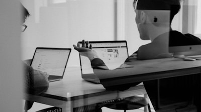 Business professional using a MacBook laptop in a modern workspace.